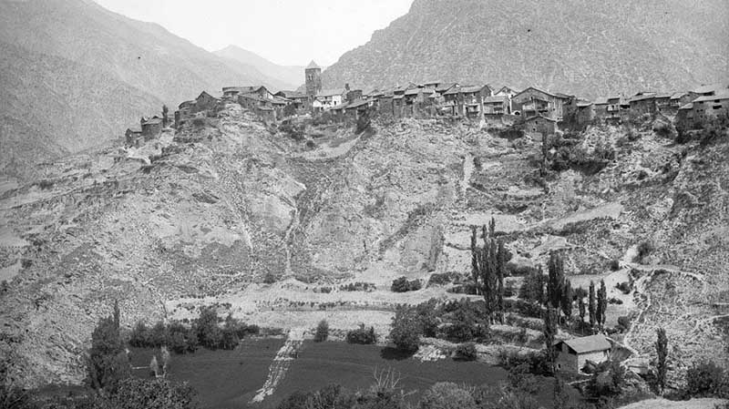 Vista general de Tírvia l’any 1894, amb el nucli antic del poble, l’església i les cases de pedra envoltades de camps i muntanyes del Pallars Sobirà.