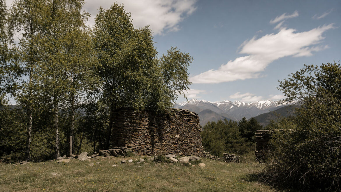 Antiga borda en ruïnes a les Bordes d’Arnui, prop de Llavorsí, envoltada de prats i vegetació, al Pallars Sobirà.