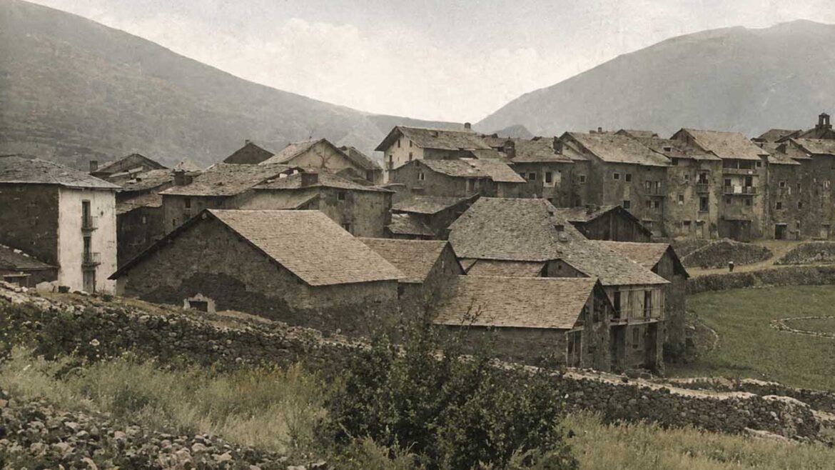 Recreació en color desaturat de Tírvia a començaments del segle XX, amb les cases de pedra i teulades de pissarra agrupades al voltant del nucli antic, entre camps i muntanyes.