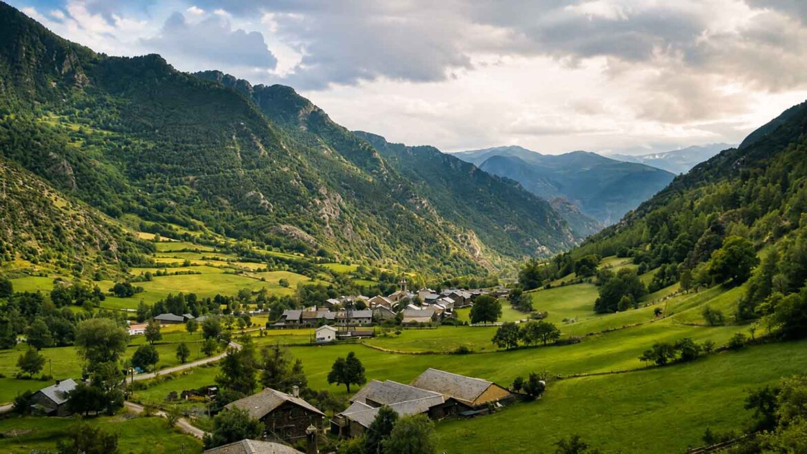 Vista panoràmica d’Àreu i de la Vall Ferrera, amb el poble envoltat de prats i boscos entre els vessants de la vall.