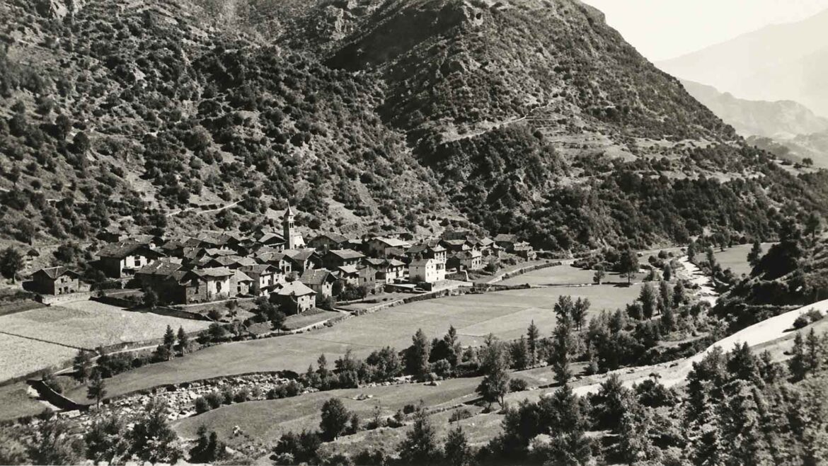 Vista d’Ainet de Besan, a la Vall Ferrera, durant les dècades de 1940–1950, amb el nucli de cases envoltat de camps cultivats, prats i petites parcel·les que ocupaven bona part del fons de la vall.