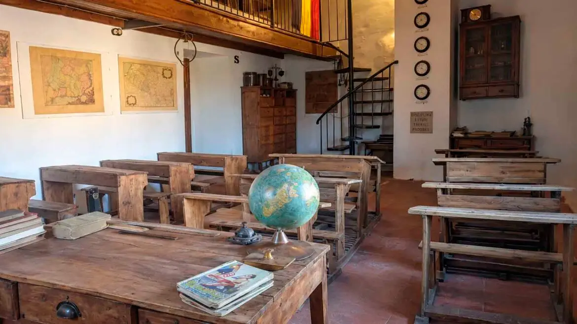 Recreació de l’antiga escola de Vilamolat de Mur, amb els pupitres de fusta, la taula del mestre, mapes escolars, un globus terraqüi i el mobiliari conservat de l’aula.