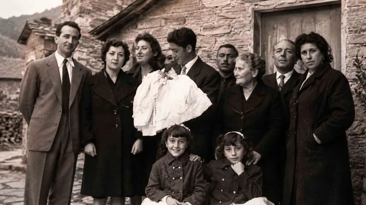 Grup de persones de diverses generacions reunit davant d’una casa pirinenca, en una recreació editorial inspirada en una fotografia històrica de Casa Maçano.